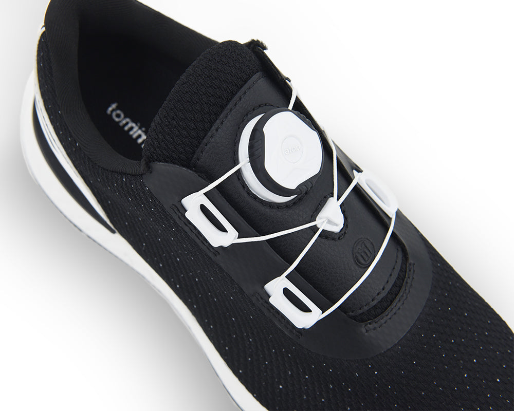 Black indoor cycling shoe with white sole on a light gray background